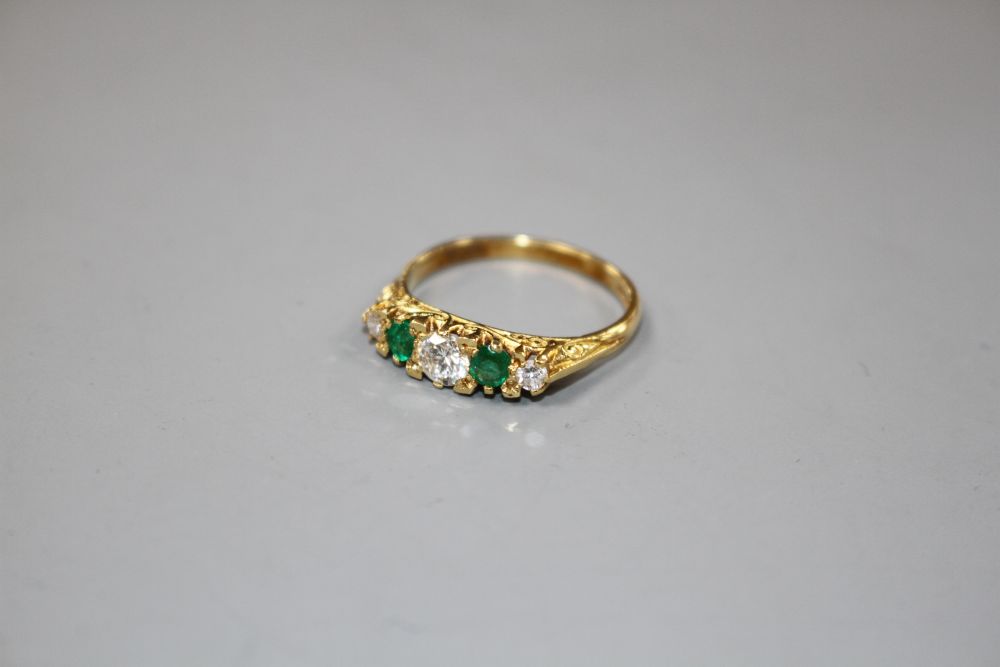 A modern Victorian style 18ct gold, two stone emerald and three stone diamond set half hoop ring,
